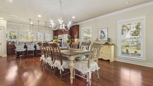 A spacious dining area with a wooden table and chairs, a chandelier, and large windows with blinds. - "Will O Mist" - Inlet Beach Home, Bikes, Pool, Dock (Inlet Beach)