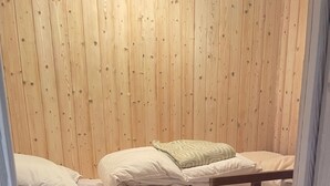 A bunk bed with a wooden headboard and a lower bunk with a mattress and pillows.