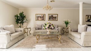 A spacious living room with two beige sofas, a glass coffee table, and a chandelier. - Comfort Private room with queen bed & study (Preston)