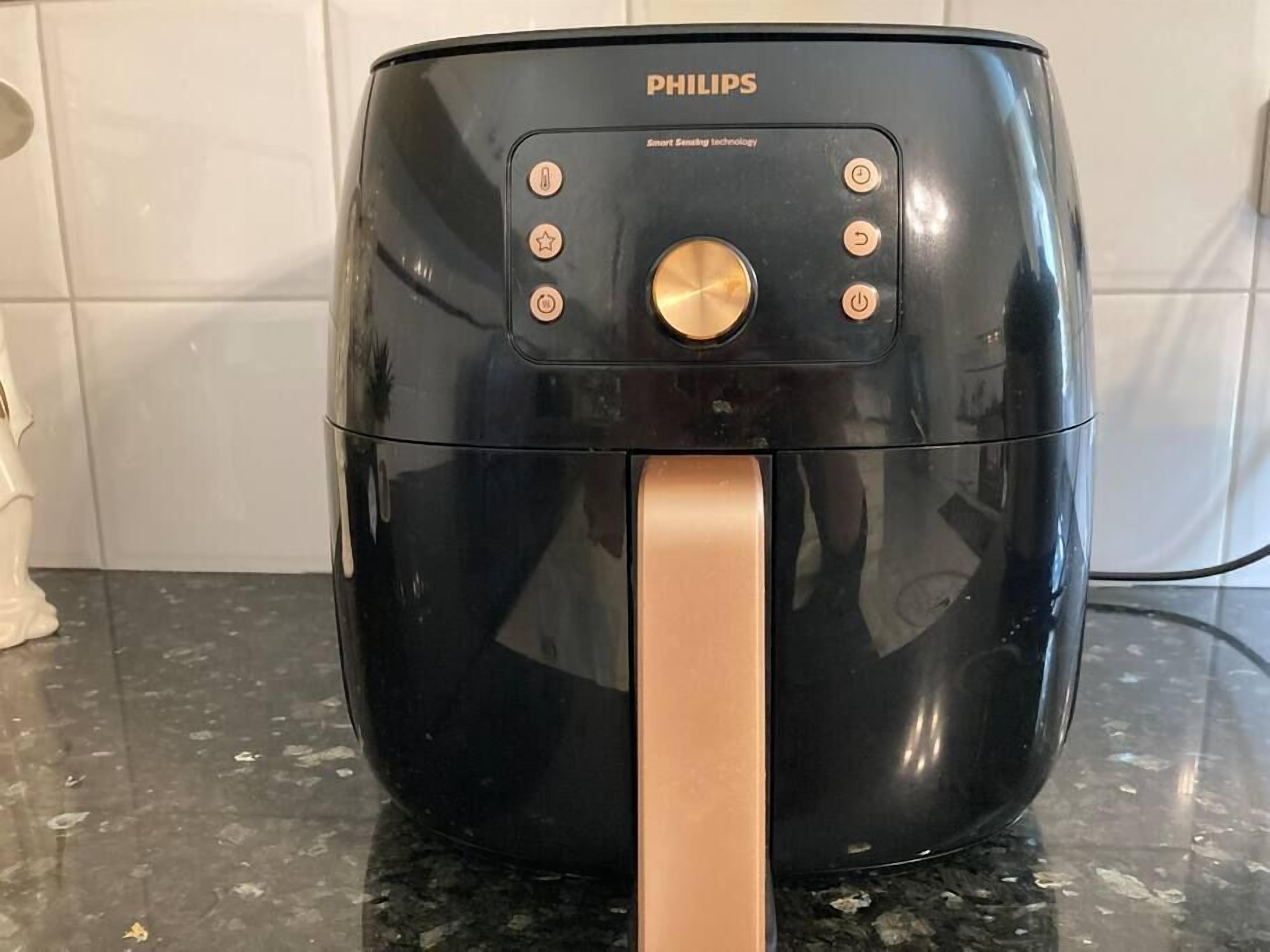 A black Philips air fryer with a control panel and a single power button.
