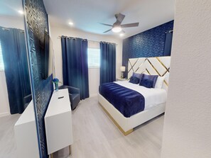 A modern bedroom with a bed, bedside table, and a desk. - Bernie Pool Home 8 BED (Orlando)