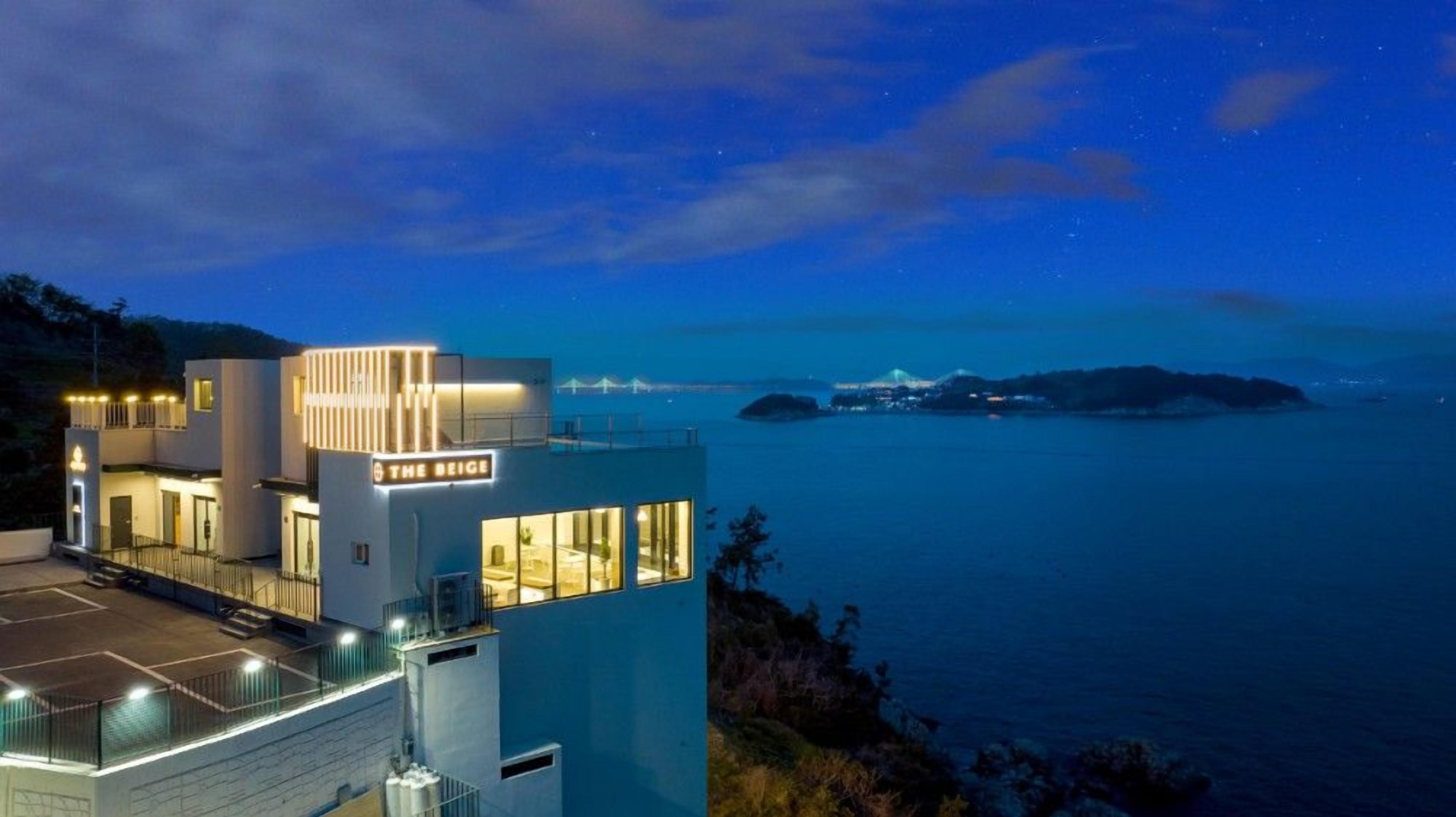 A modern hotel with a rooftop terrace overlooking the sea, named "The Beige".