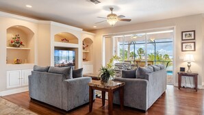 A spacious living room with two grey sofas, a wooden coffee table, and a ceiling fan. - Where waters intersect and Dreams unwind! Kayak, Bikes, Heated Pool & Spa - Villa Cayman - Roelens (Cape Coral)