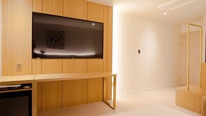 Ein modernes Wohnzimmer mit Flachbildfernseher an einer Holzwand, einer eingebauten Unterhaltungseinheit und minimalistischem Design.