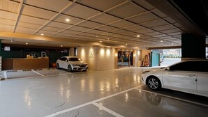 Eine moderne Hotelhalle mit großzügigem Parkplatz, einer Rezeption und einer Backsteinwand.