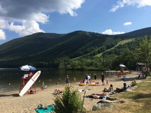 Enjoy a family-friendly lakeside beach with umbrellas, a lifeguard stand, and beach games.