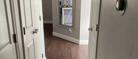 A hallway with wooden flooring and white doors.