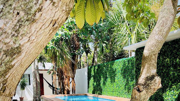 Ein Poolbereich mit Holzterrasse, einem kleinen Tisch und zwei Stühlen.