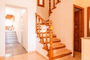 Un escalier en bois, doté d’une rampe, mène à un palier.