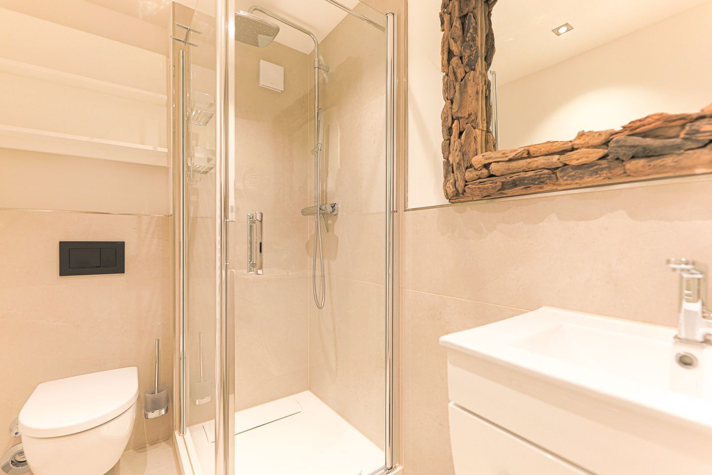 A modern bathroom with a glass-enclosed shower, a white toilet, and a sink with a mirror above it.