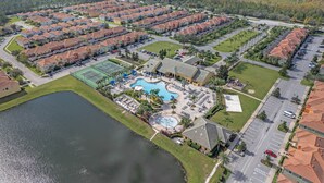 A residential area with multiple apartment buildings, a swimming pool, and a tennis court. - ⭐️New listing 5 mi from Disney/Free Arcades, HeatedPool & Water park🌊 (Kissimmee)