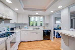 A modern kitchen with white cabinetry, a built-in oven, and a dishwasher.