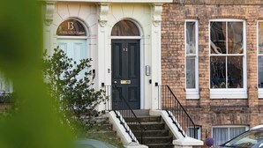 A two-story building with a dark blue door labeled "Royal Crescent" and the number 12. - Crescent View | Central & Quiet | Sleeps 4 (North Yorkshire)