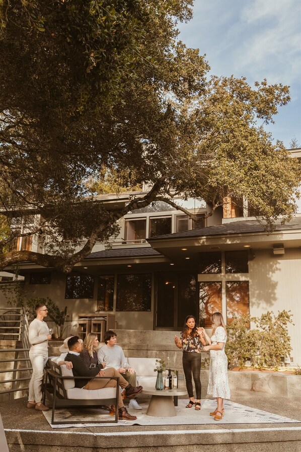 A modern house with a patio area where people are gathered.
