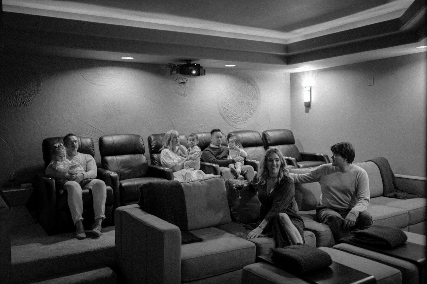 A home theater room with leather recliners and a large screen.
