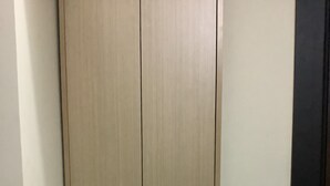 Een gesloten kast met twee handgrepen en een lichtschakelaar op de muur.