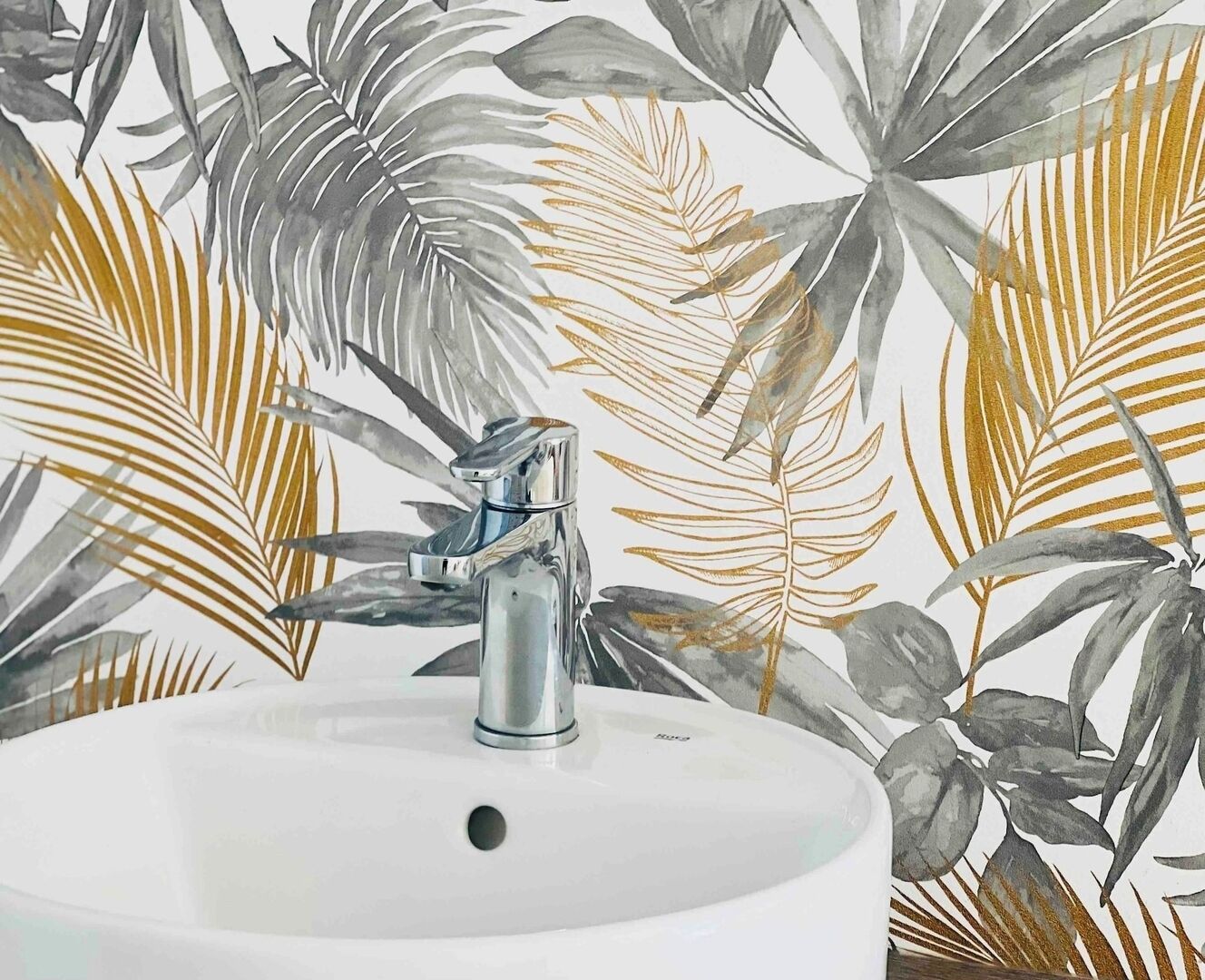 Une salle de bain avec un lavabo blanc et un robinet moderne.