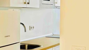 Una cocina equipada con refrigerador, pileta, microondas y lavavajillas.