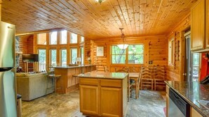 A log cabin interior with a kitchen, dining area, and living space. - Home Sweet Log (Wisconsin Dells)