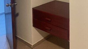 A room with a wooden door, a white wall, and a built-in wooden cabinet with drawers. - Hospedaje La Pascana (Cajamarca)