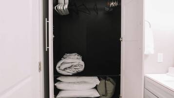 Een kast met opgevouwen kleding en een kledingroede.