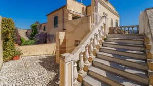 Una escalera de piedra que lleva a un edificio con balcón.