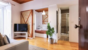 A modern living room with a television, sofa, and a potted plant.