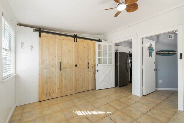 A spacious kitchen with a sliding barn door, a refrigerator, and a ceiling fan.