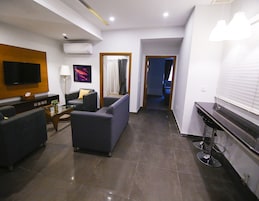 Una sala de estar moderna con una televisión de pantalla plana, un sofá, una mesa de centro y un mueble para televisión.