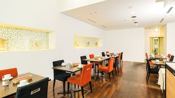 Uma sala de jantar moderna com várias mesas e cadeiras, um balcão de cozinha e painéis decorativos na parede.