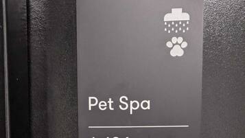 A sign for a Pet Spa labeled A-106 on a black wall.
