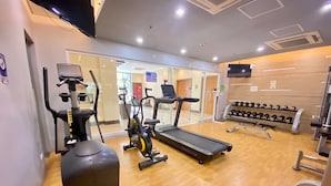 A gym with cardio equipment, weight machines, and a treadmill. - Beautiful Studio Near Resorts World NAIA T3 (Pasay)