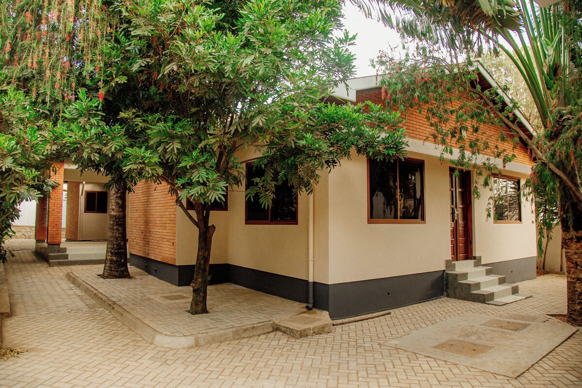 A building with a tiled walkway, a wooden door, and a window.