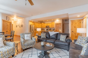 Relax in this open-plan living area with a modern kitchen, comfortable sofa, and dining space.