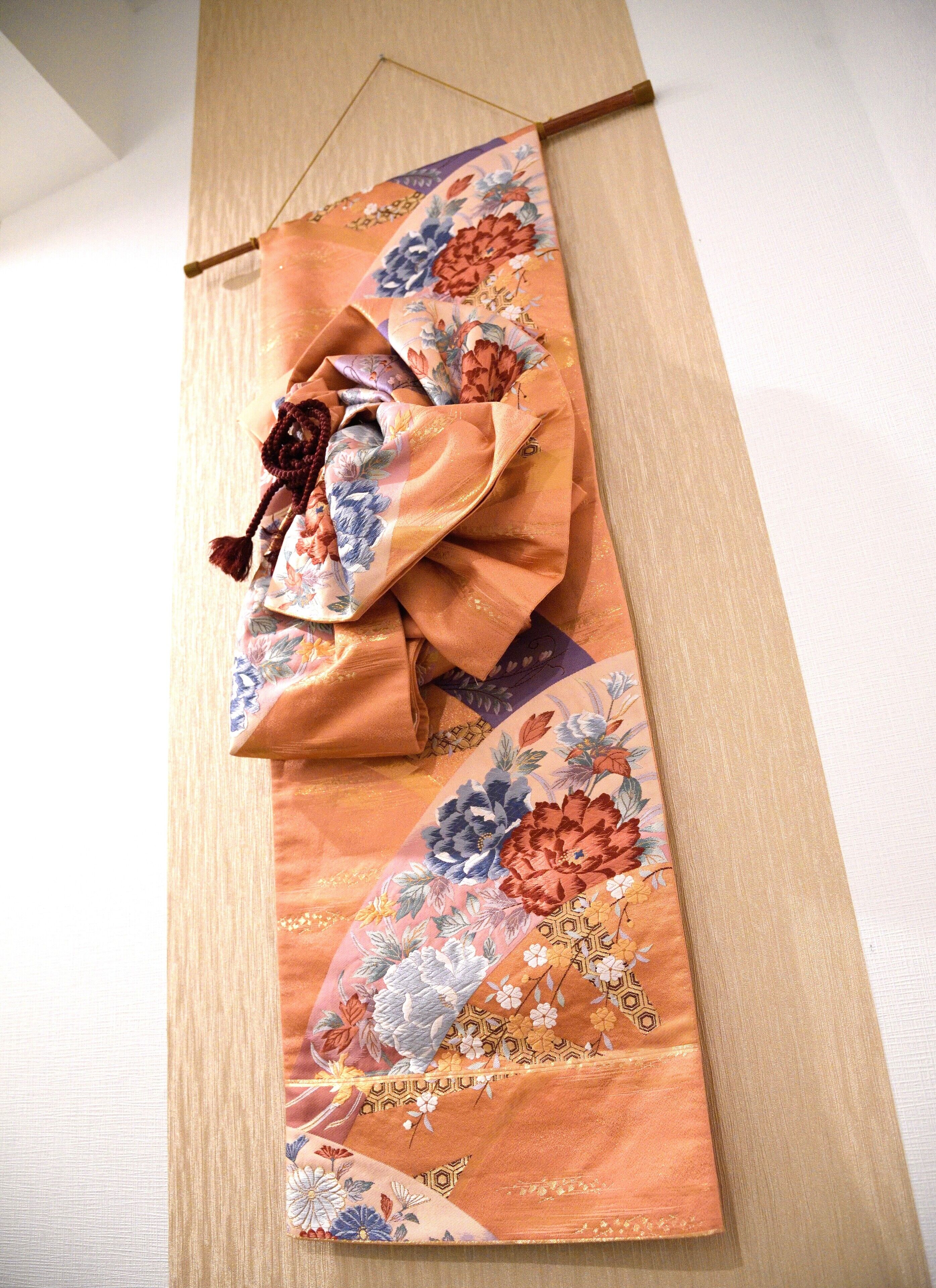 A traditional Japanese garment with floral patterns, displayed on a wooden surface.