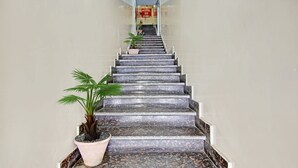 Un escalier menant à l’entrée d’un hôtel, avec une enseigne indiquant « HÔTEL 03 ».