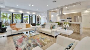 A modern living room with white sofas, a glass coffee table, and a colorful rug. - Lynora`s Luxe Estate - 3BR/3BA w/ Modern Design & Heated Pool (Fort Lauderdale)