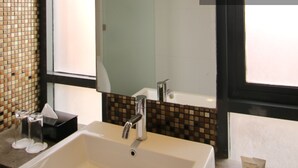 A bathroom with a white sink, a mirror, and a window. - Liberta Hotel Jimbaran (Kedonganan)