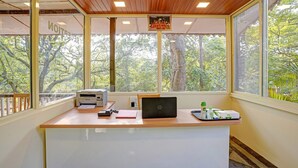 A reception desk with a printer, a laptop, and a tray with toiletries. - Treebo Cecil Resort Matheran (Karjat)