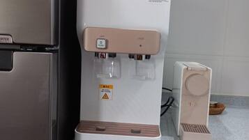 A kitchen with a white WINIX water dispenser and a Cuckoo coffee machine.