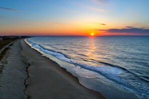 Enjoy a serene beach experience with gentle waves lapping against the shore.