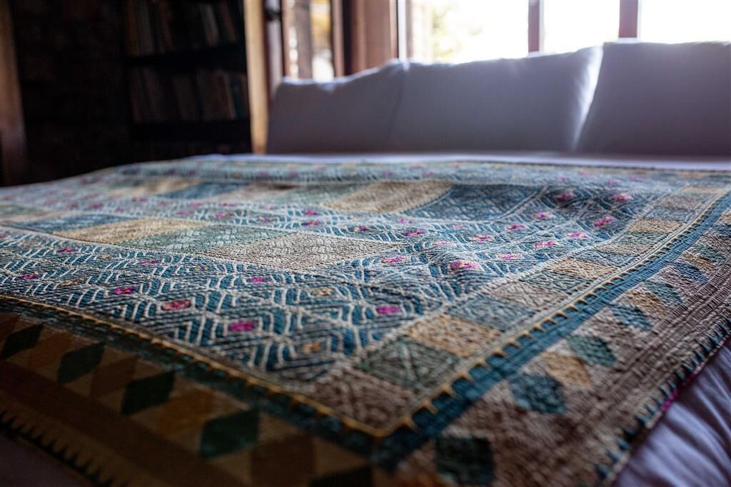 Una cama con un edredón y almohadas estampadas.