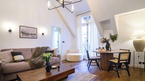 En moderne stue med sofa, sofabord og spiseområde med stole.