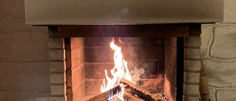 A fireplace with a stone surround and a white mantel.