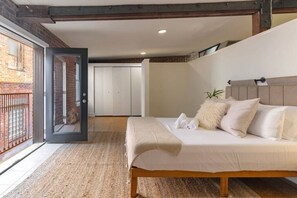 A bedroom with a bed, a door leading to a balcony, and a white wardrobe. - Deluxe 3BR Loft Walkable to Everything Downtown (Cincinnati)