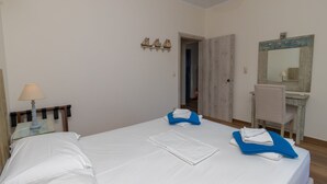 Une chambre d’hôtel avec un lit, un bureau, une chaise et un miroir.