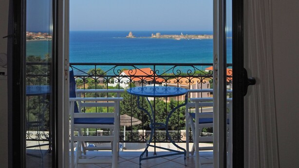 Un balcon avec vue sur la mer et les bâtiments.