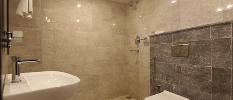 A modern bathroom with a sink, toilet, and shower.