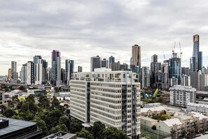 Un paisaje urbano con rascacielos, incluyendo un edificio blanco destacado con fachada de entramado y un rascacielos moderno con un diseño único.