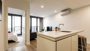 A modern kitchen with a central island, a built-in oven, and a window overlooking a cityscape.